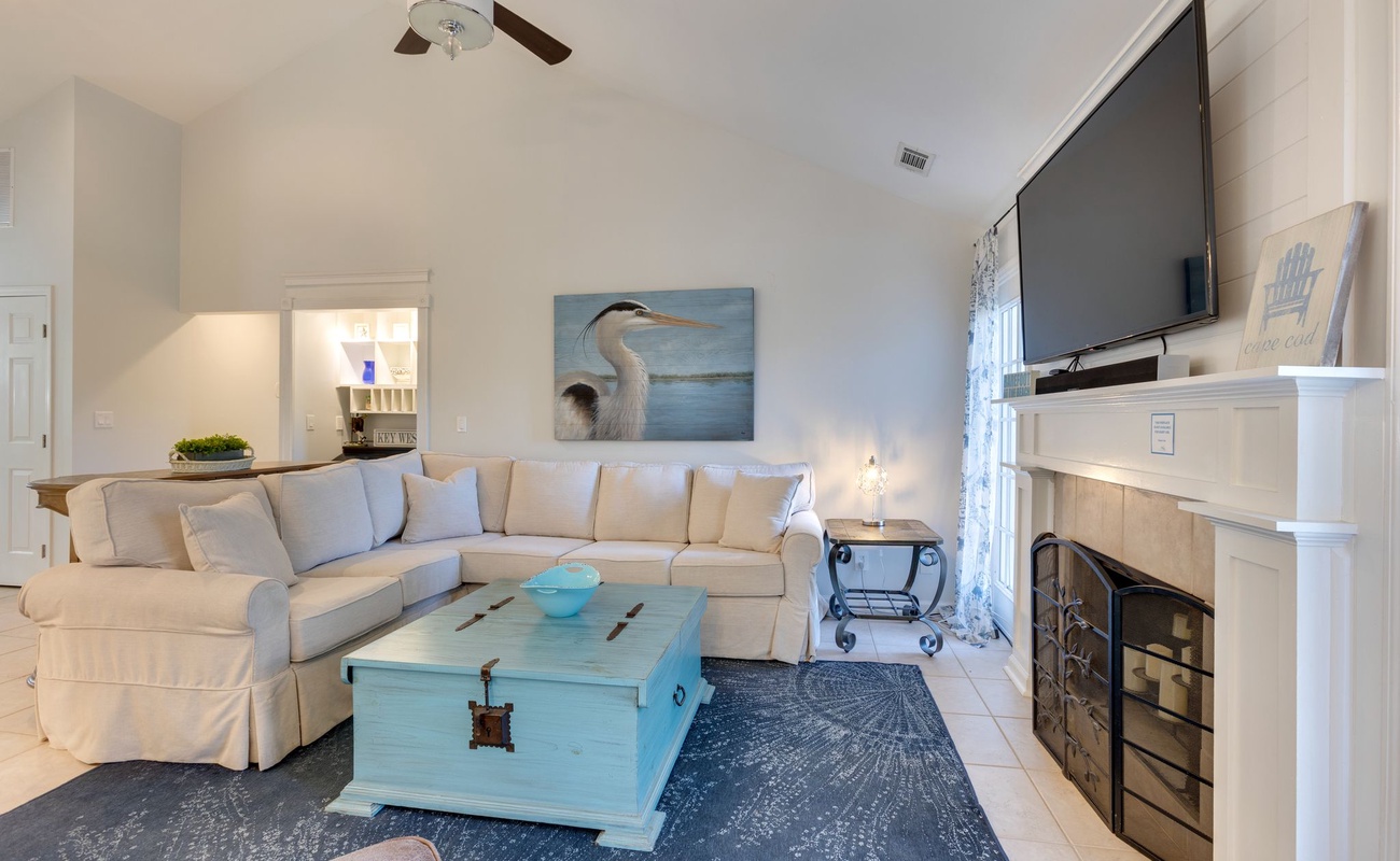 Sink into this coastal-inspired living room where soft whites meet ocean blues. Your perfect retreat features a fireplace for cozy evenings.