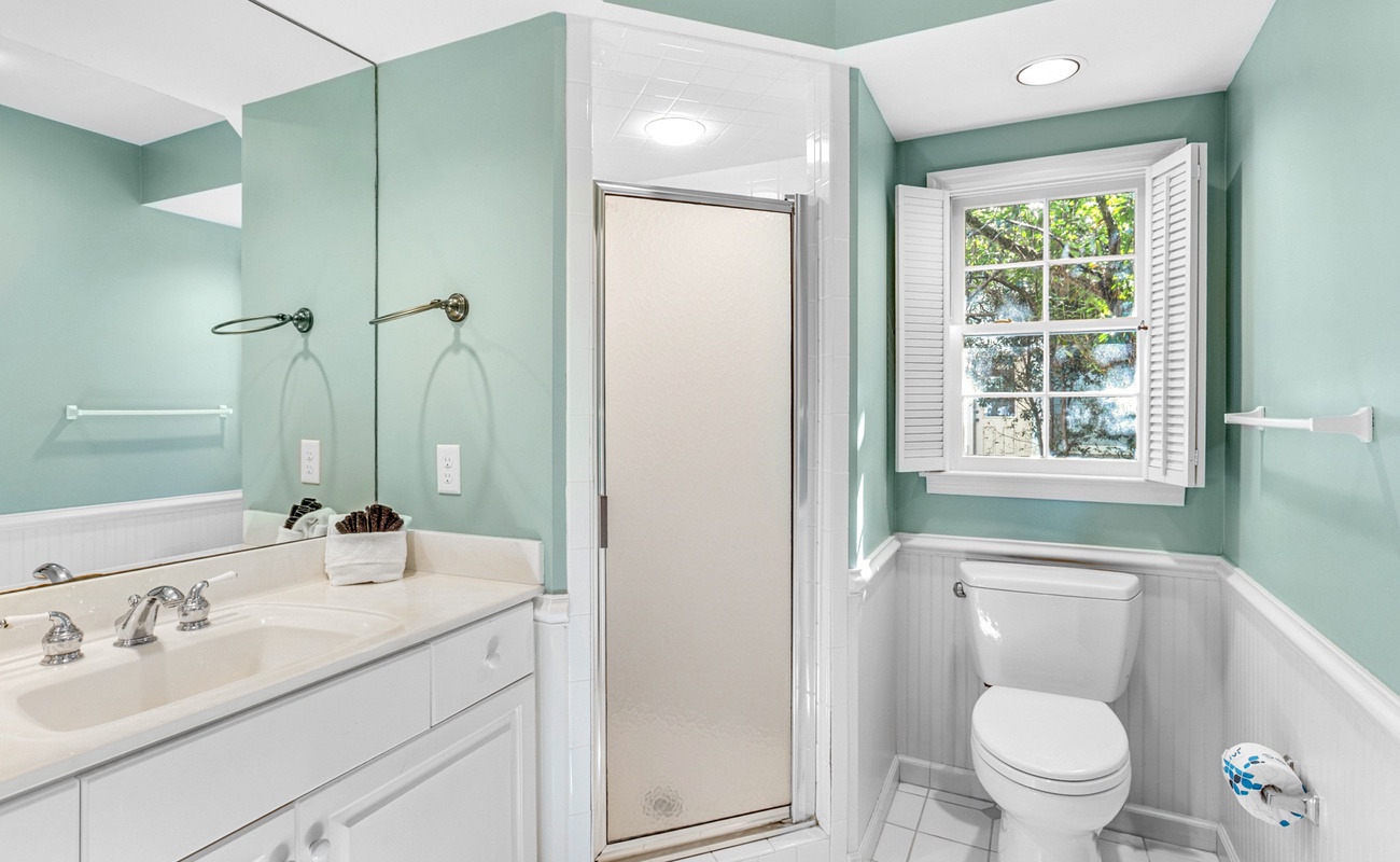 Your spa-inspired bathroom features soothing mint walls, marble counters, and a glass shower where you'll refresh each morning.