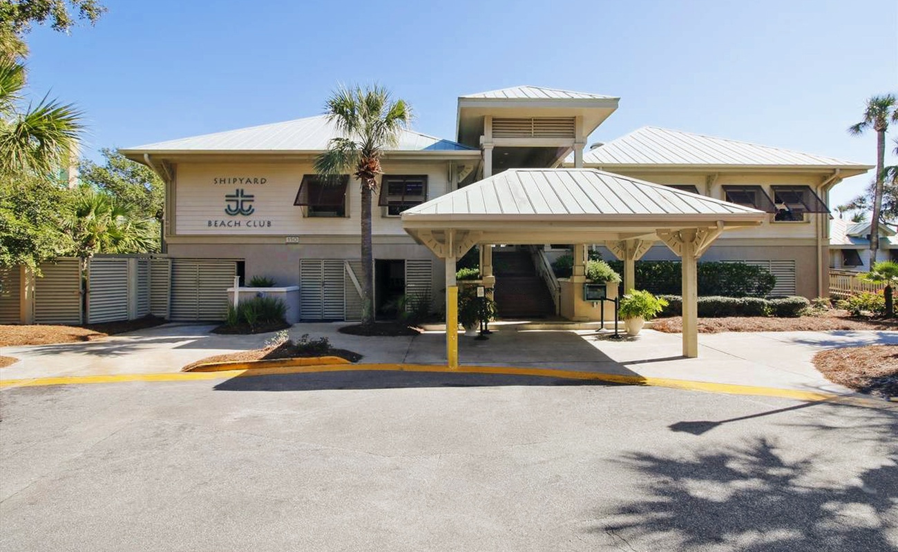 Modern beachside resort building with tropical landscaping and covered entry creates a welcoming coastal atmosphere.