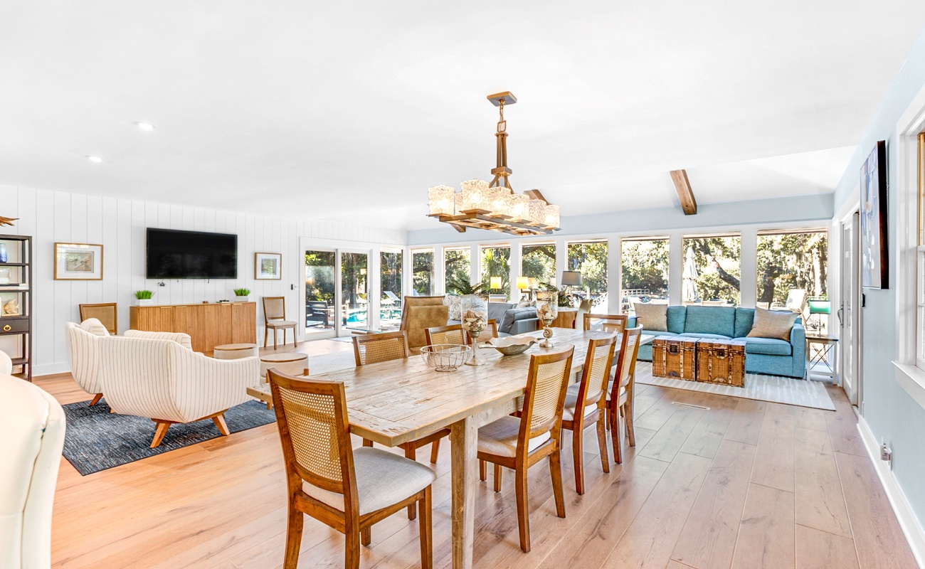 Your bright open-plan living space flows seamlessly from kitchen to dining, with panoramic windows framing leafy garden views.