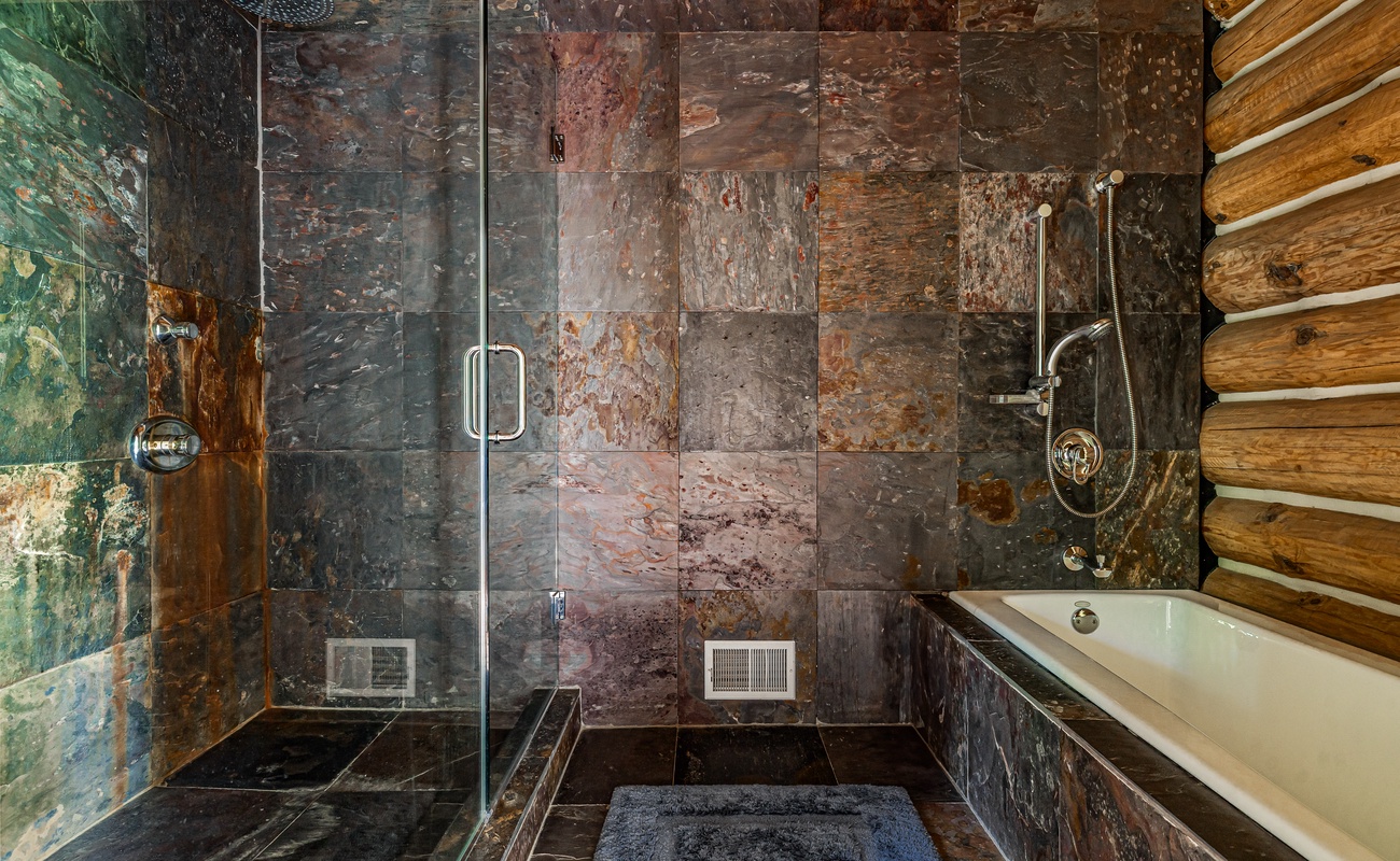 Slate-tiled shower + soaking tub = cabin spa vibes