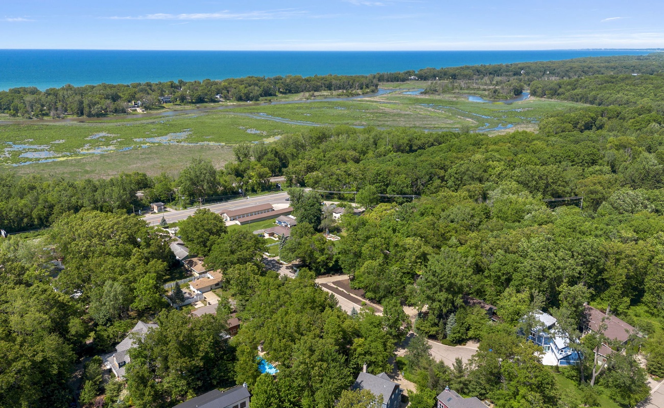This aerial view captures the beauty of a home surrounded by lush greenery.