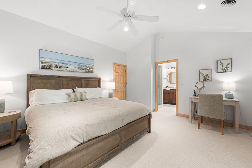 The primary bedroom is on the upper level & has a king bed + dedicated workspace.