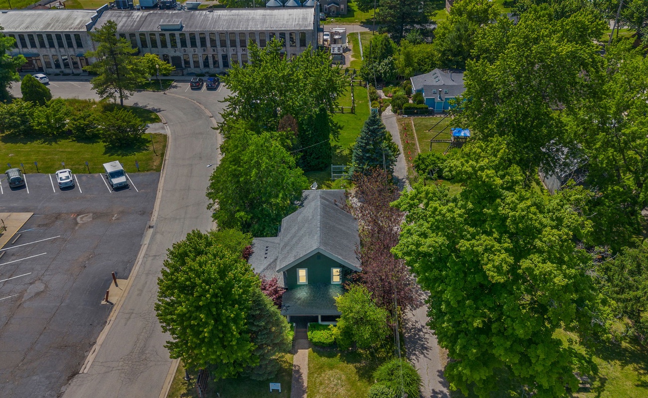 Elevate your perspective with this breathtaking aerial shot of a charming residential neighborhood. The vibrant trees and busy streets below showcase the perfect blend of nature and modern living.