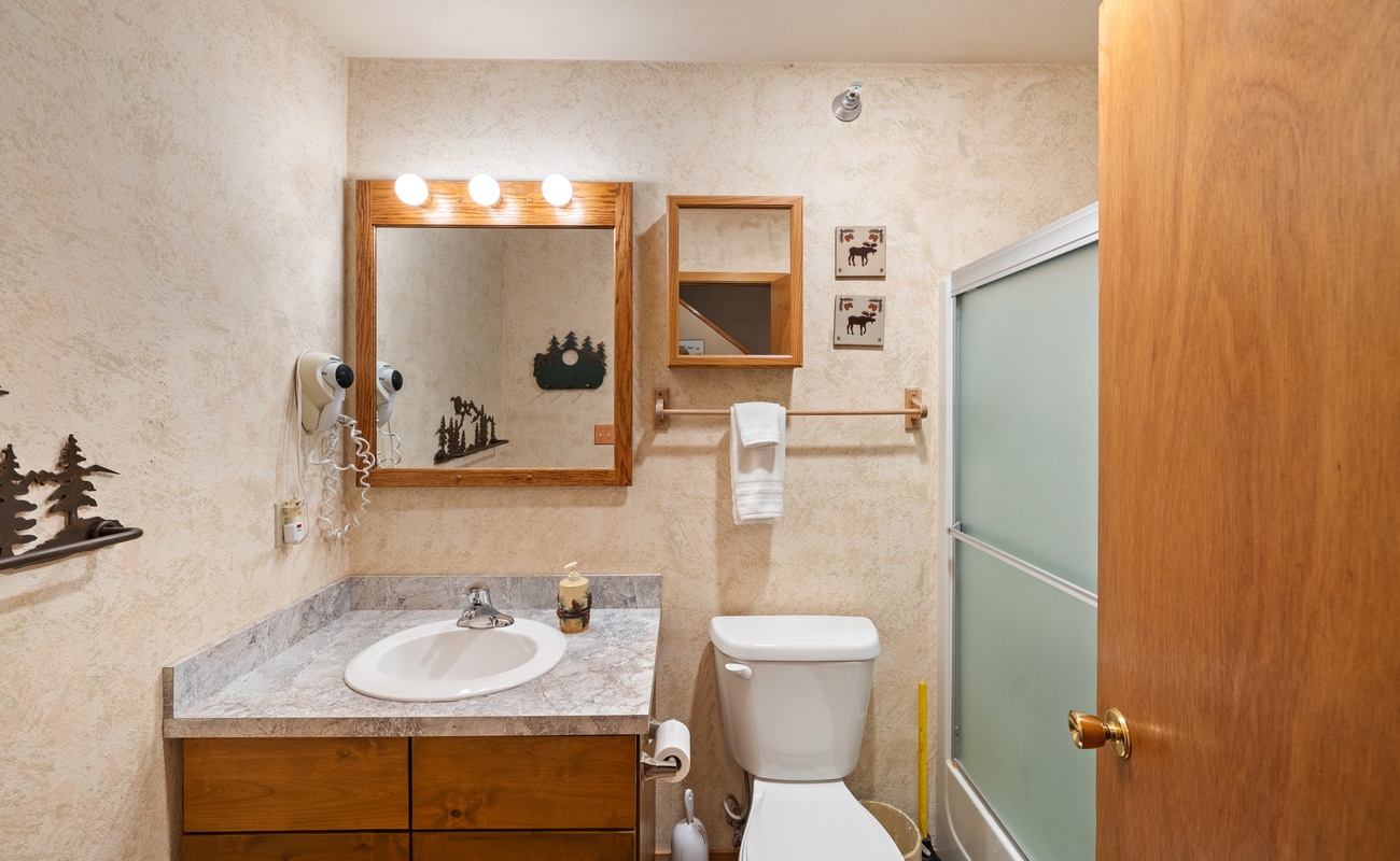 This bathroom setup is perfect for unwinding after a long day. Sink, shower, and toilet—everything in one serene space.