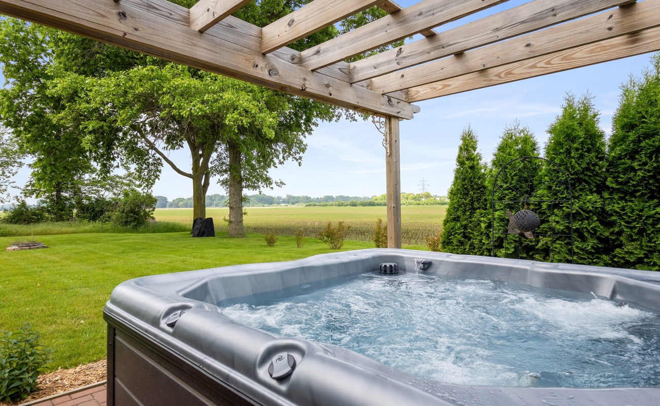 Soak under the pergola with peaceful views of open fields.