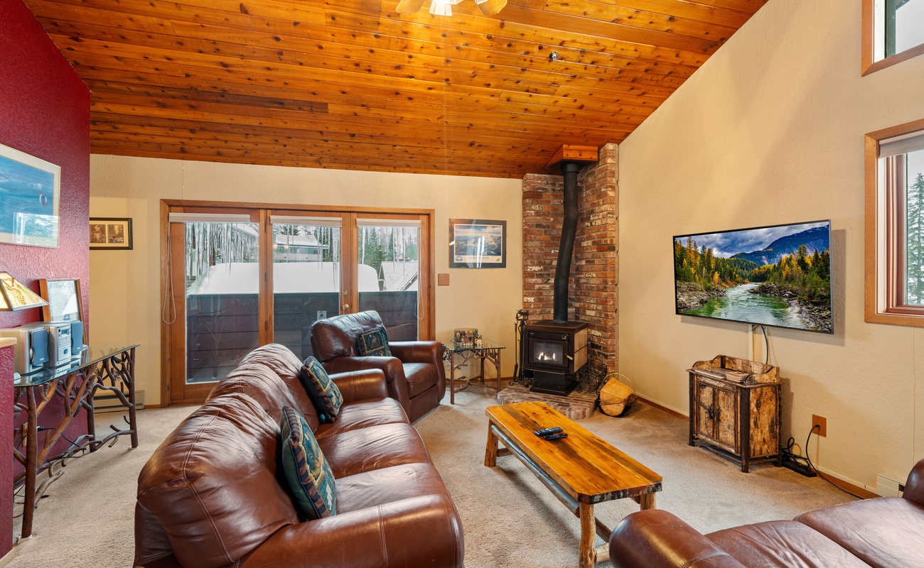 A warm and inviting living room with a wood-burning fireplace and a comfortable couch.
