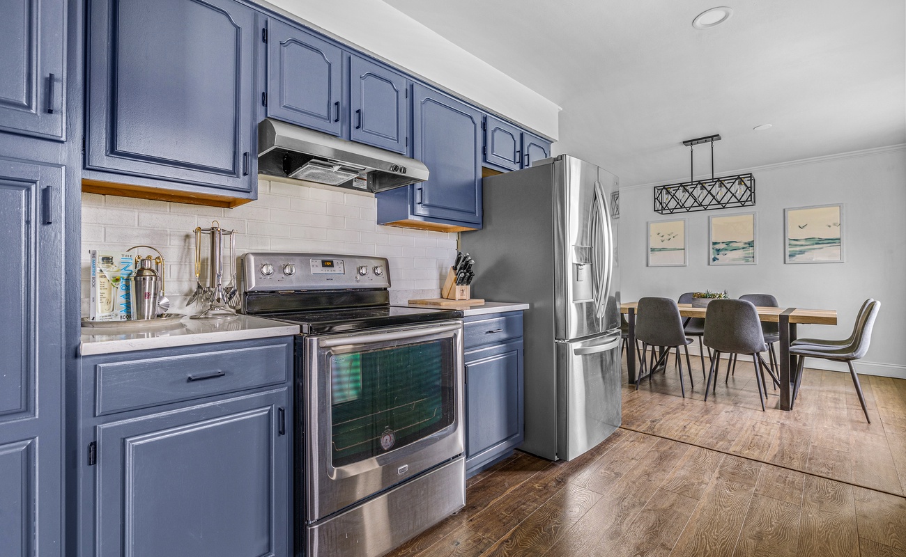 The blue cabinets bring a pop of color while the stainless-steel appliances add that modern touch!
