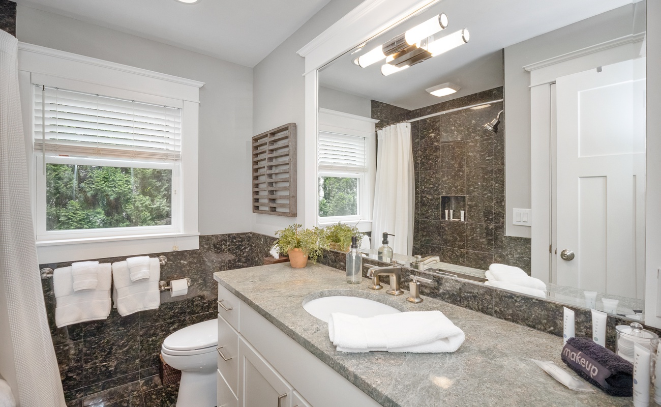 The main floor hallway bathroom features a deluxe vanity and shower-tub.