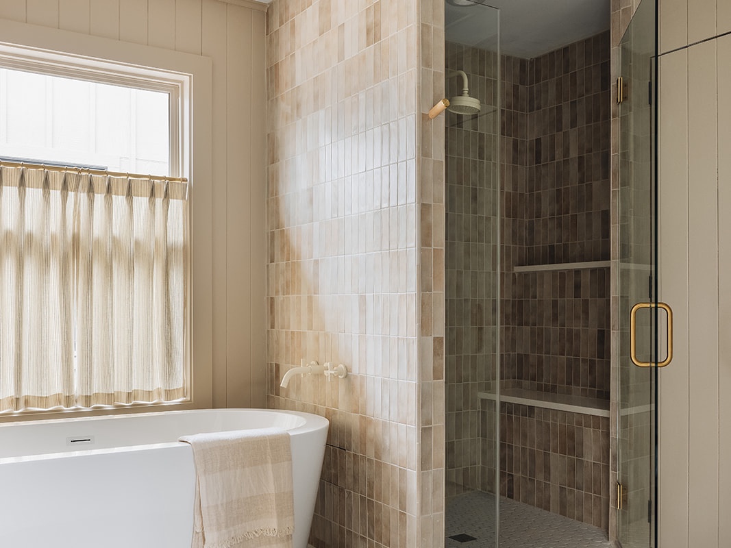 Besides a sleek relaxing tub, this bathroom features a tiled walk-in shower.