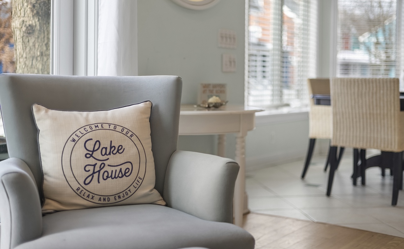 Sink into this cozy armchair with lake house charm and sunlit windows.