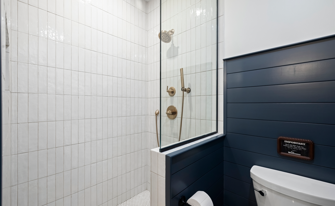 Crisp tile and brass fixtures create a spa-like shower retreat.