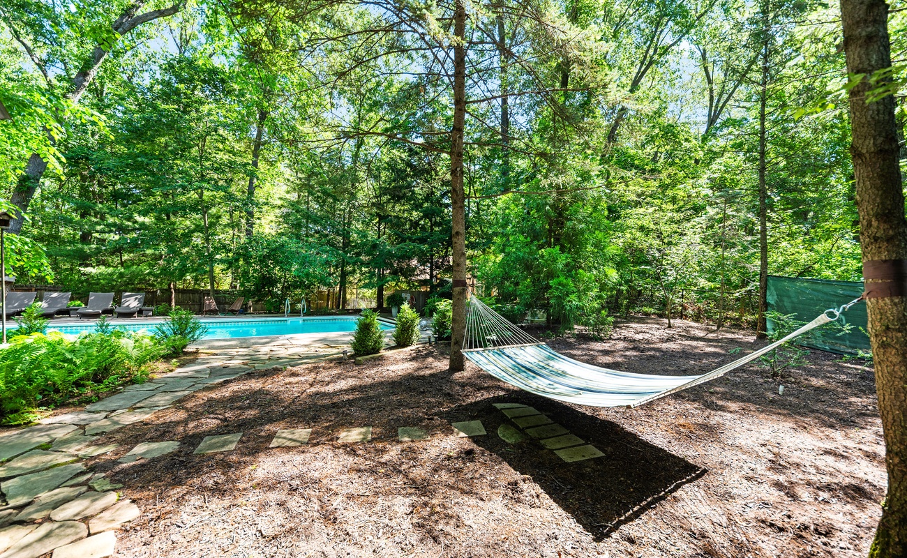 Sway beneath the trees, steps from the pool.