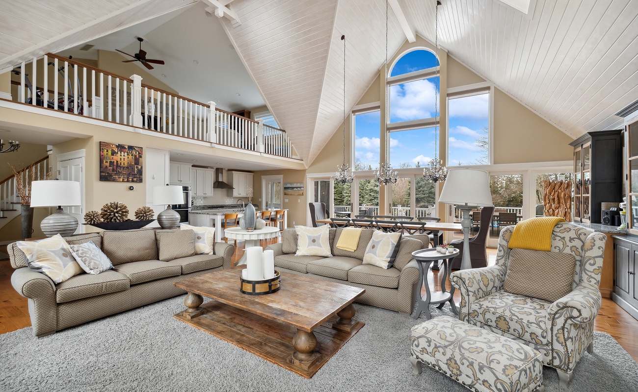 Experience the elegance of this large living room, featuring a magnificent vaulted ceiling and ample natural light. The Christmas candle brings a serene glow, perfect for celebrating the season with loved ones.