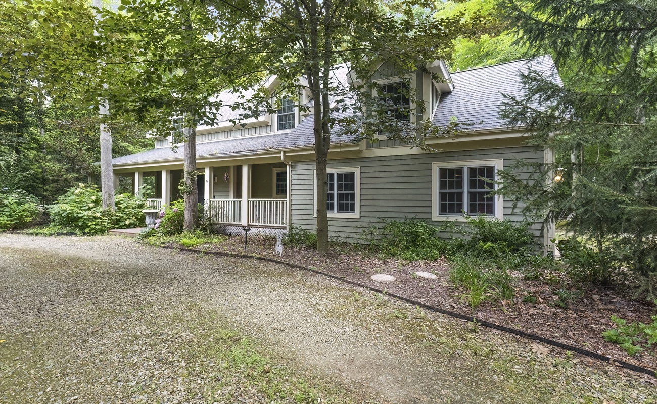Storybook curb appeal in a peaceful wooded setting.