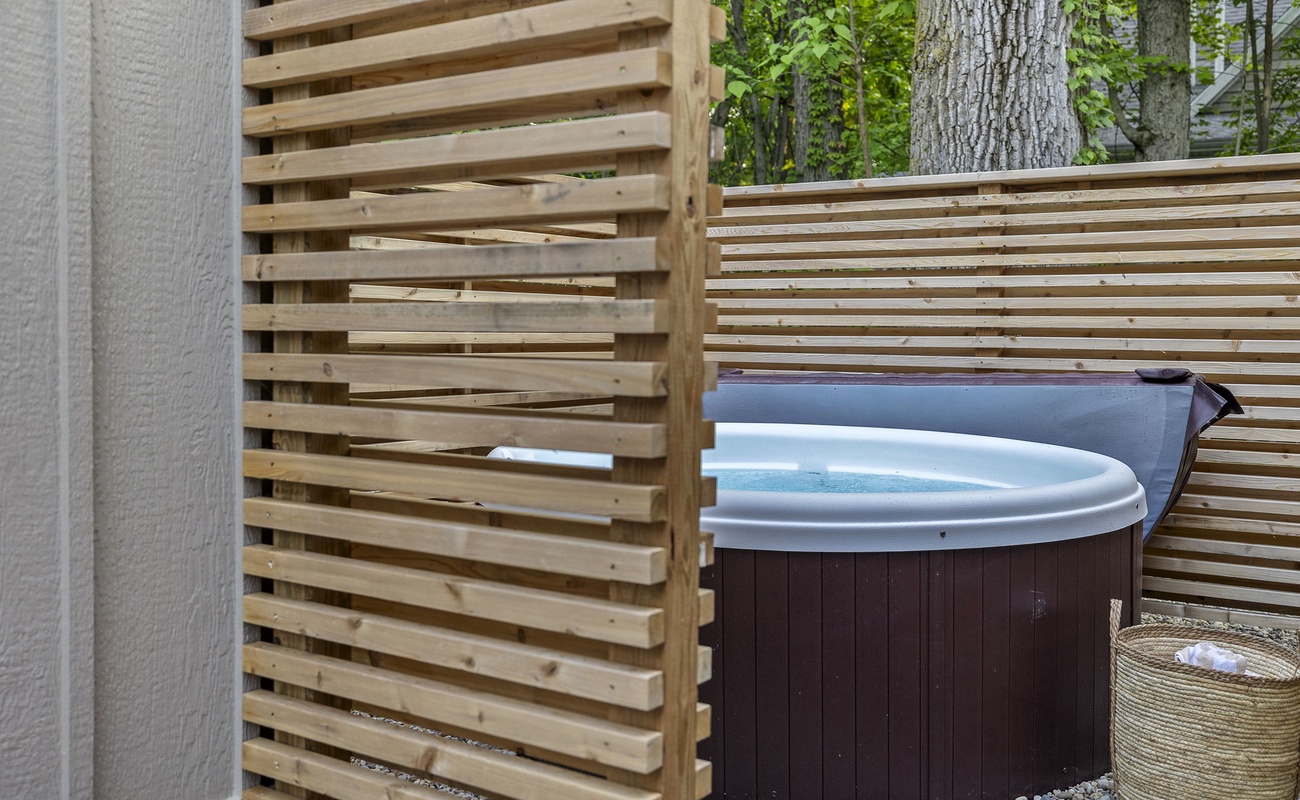 Relaxing in the backyard hot tub, surrounded by a cozy wooden fence.