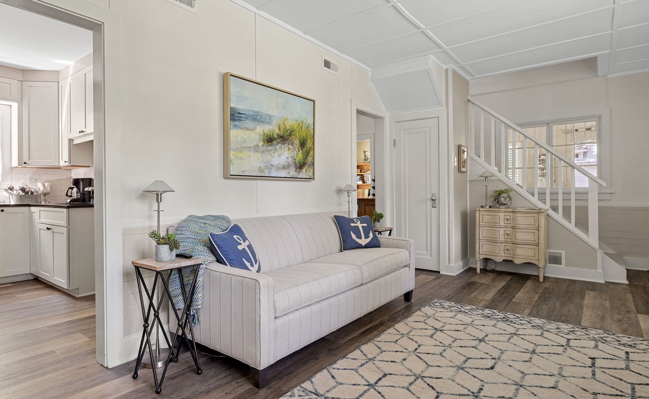 A blend of classic and coastal: the striped couch and anchor pillows offer a fresh, breezy feel, while the rustic chest adds a dash of vintage charm.