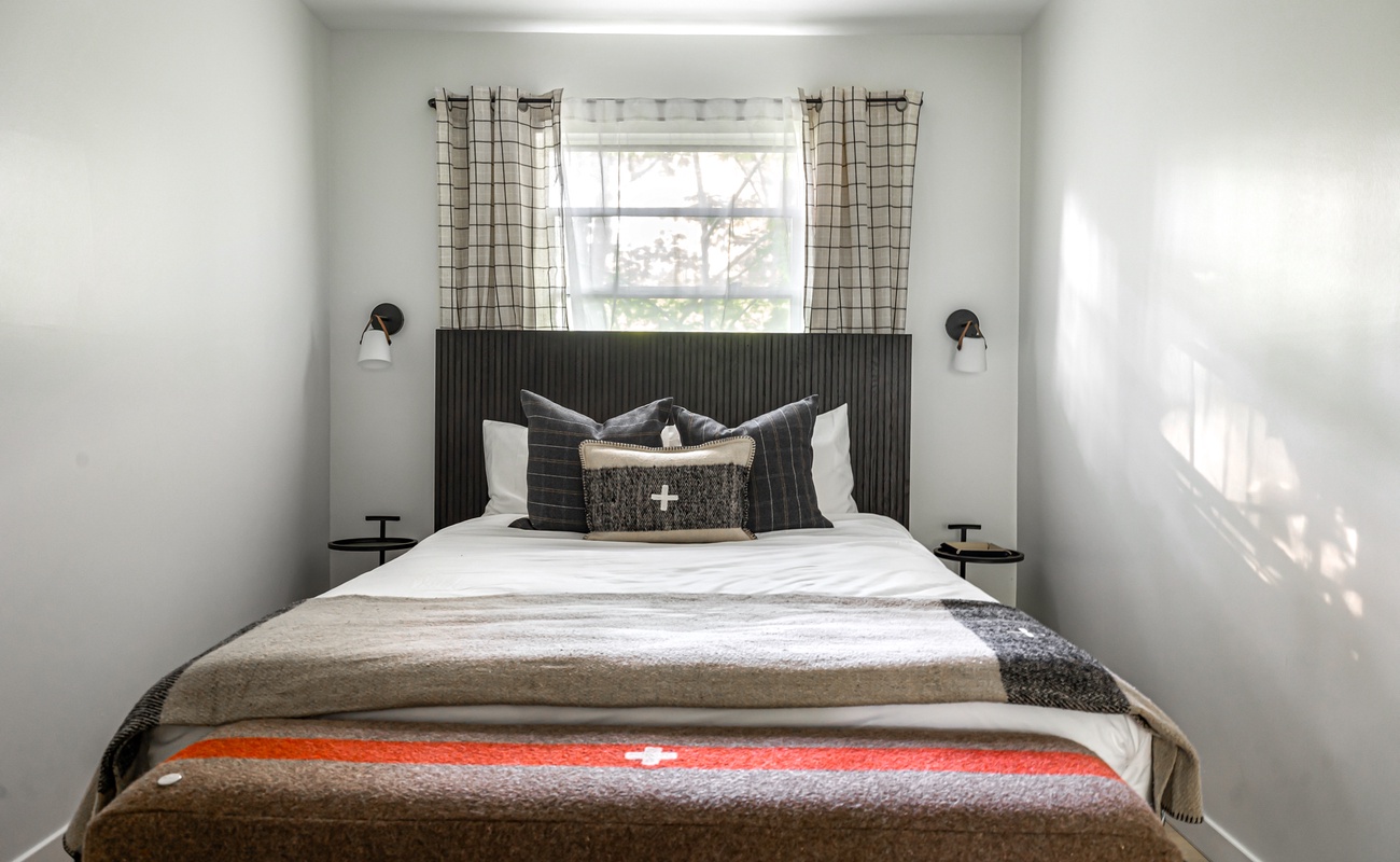 Plaid, patterns, and the perfect pop of color—this bedroom is chef’s kiss cozy.