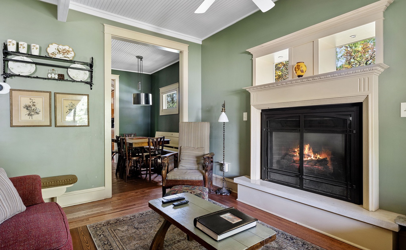 A cozy nook by the fireplace, leading to a charming dining area.