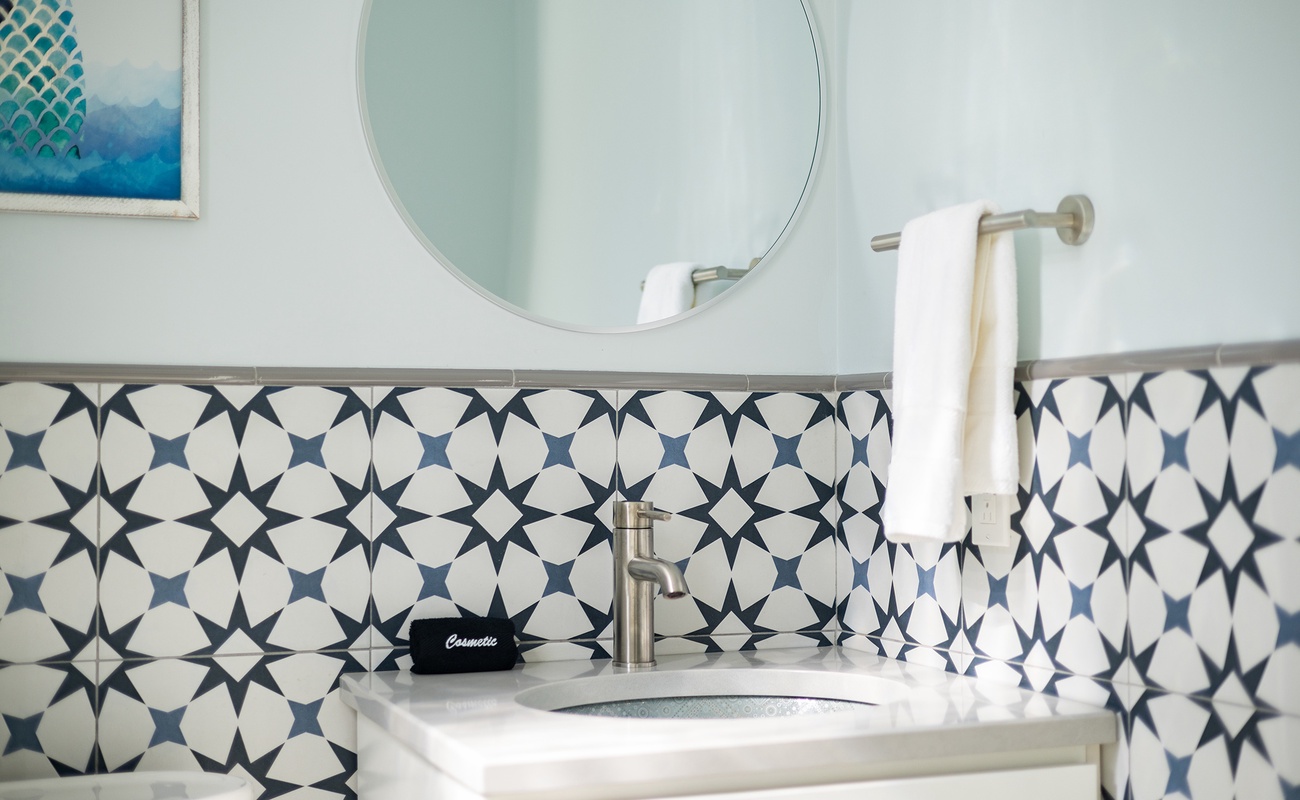 A stylish half bath with geometric tile and modern touches.