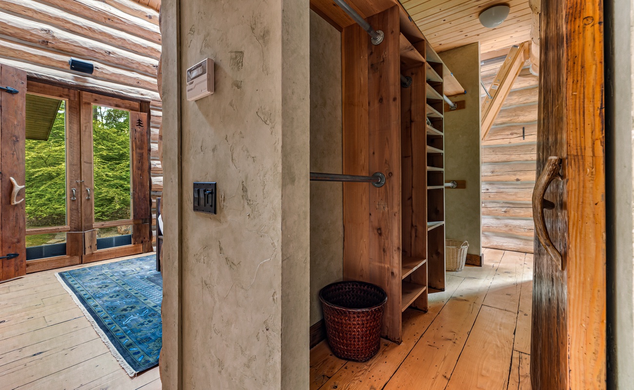 Stunning walk-in closet blends luxury with rustic log home charm.