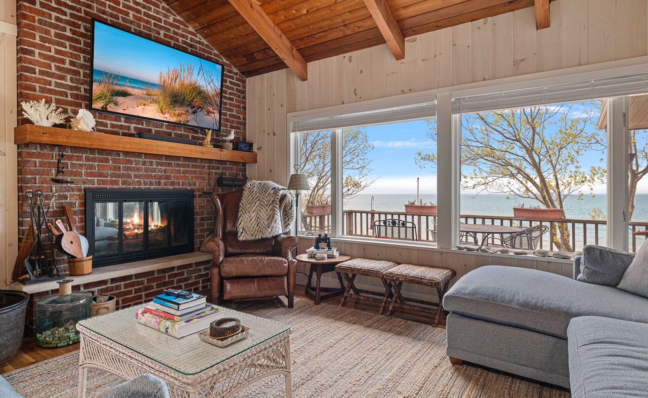 The living room has lots of comfortable seating, a fireplace and flat-screen TV.