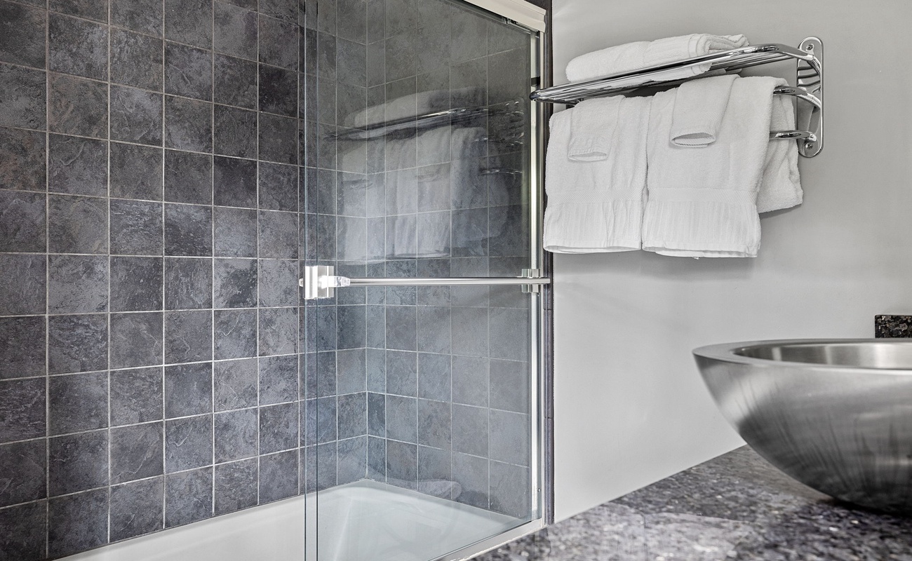 A special touch in this posh bathroom is its steel-bowl, stone-top vanity sink.