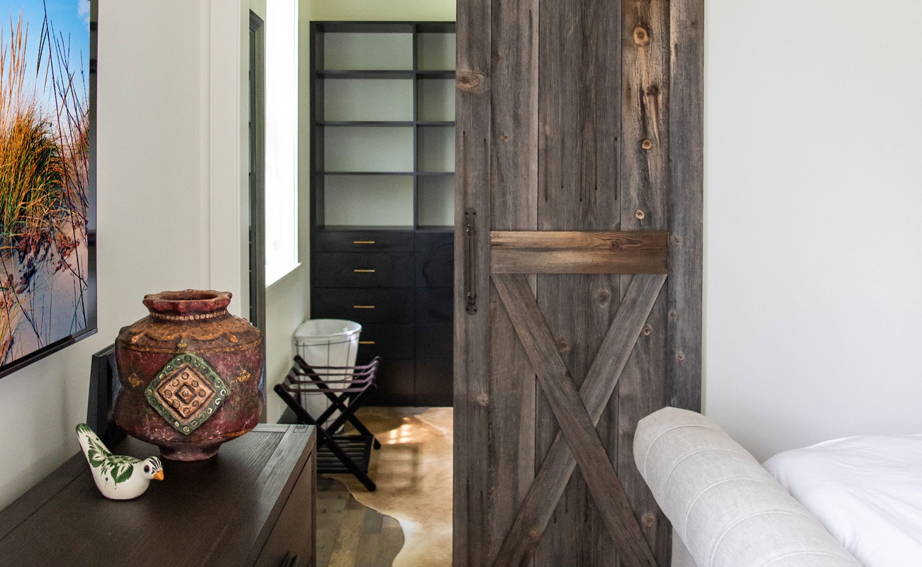 A classic barn door leads to the main bedroom’s closet.
