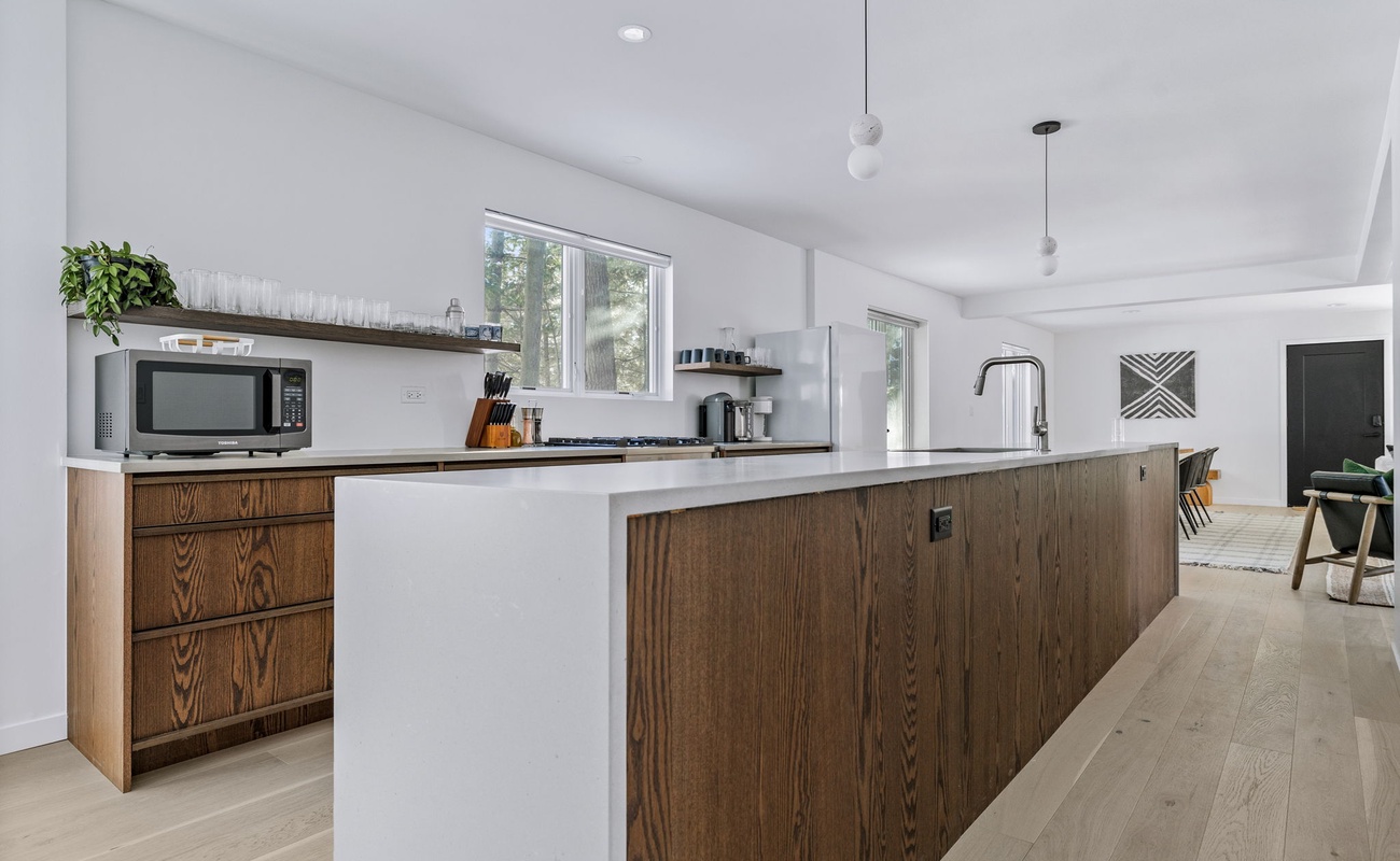 Sleek surfaces, warm wood accents, and endless counter space—this kitchen is the heart of modern elegance.