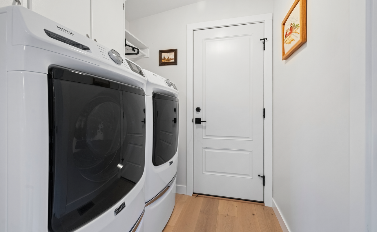 Full laundry room with washer, dryer, and storage space.