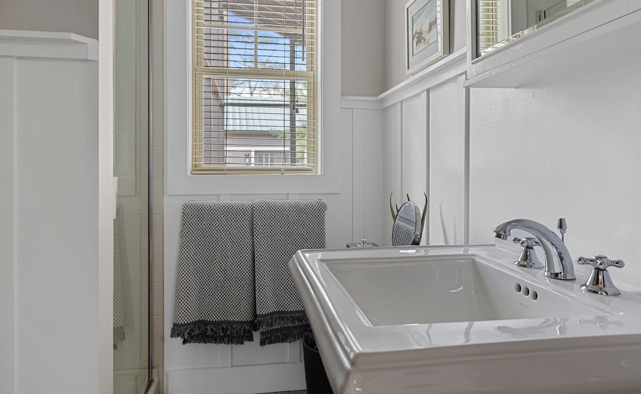 The renovated bathroom features marble-and-beach-pebbled flooring.