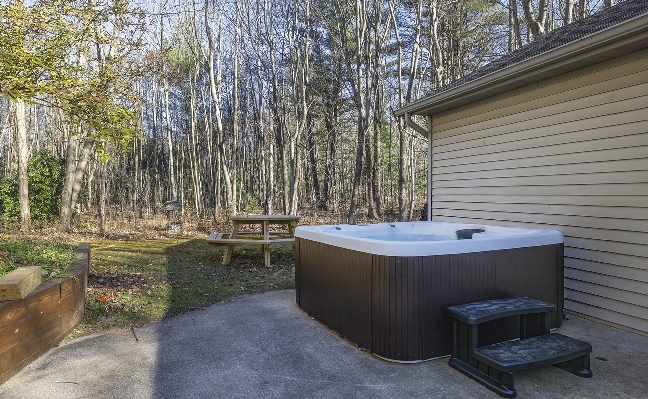 Lounge in the hot tub and take in serene woodland scenery.