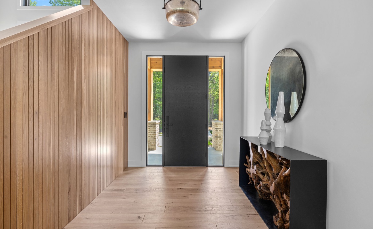 Enter the enchanting hallway with rustic wooden walls and a mysterious black door.