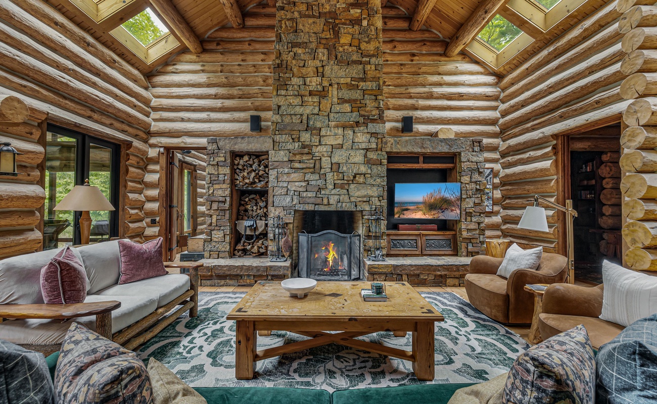 A warm, lodge-style living room with a stunning stone hearth and rustic charm.