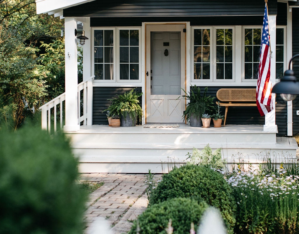 The cottage exterior greets guests with a charming wood picket gate
