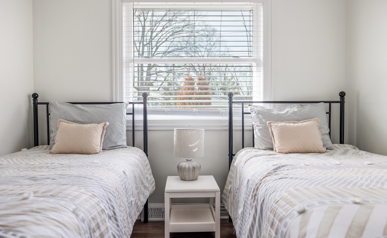 Cozy twin setup with soft light—great for guests who love space and togetherness.