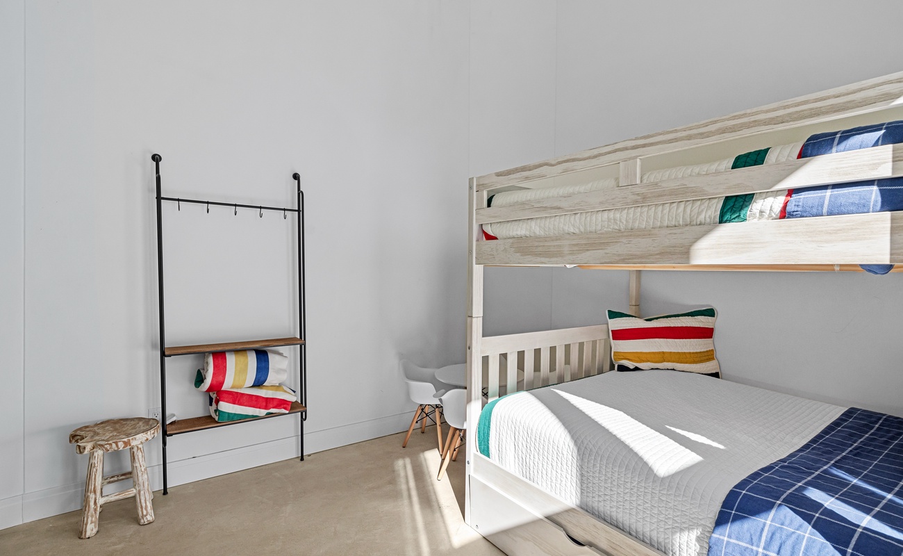 Stylish bunk room with cozy beds and soft natural light.