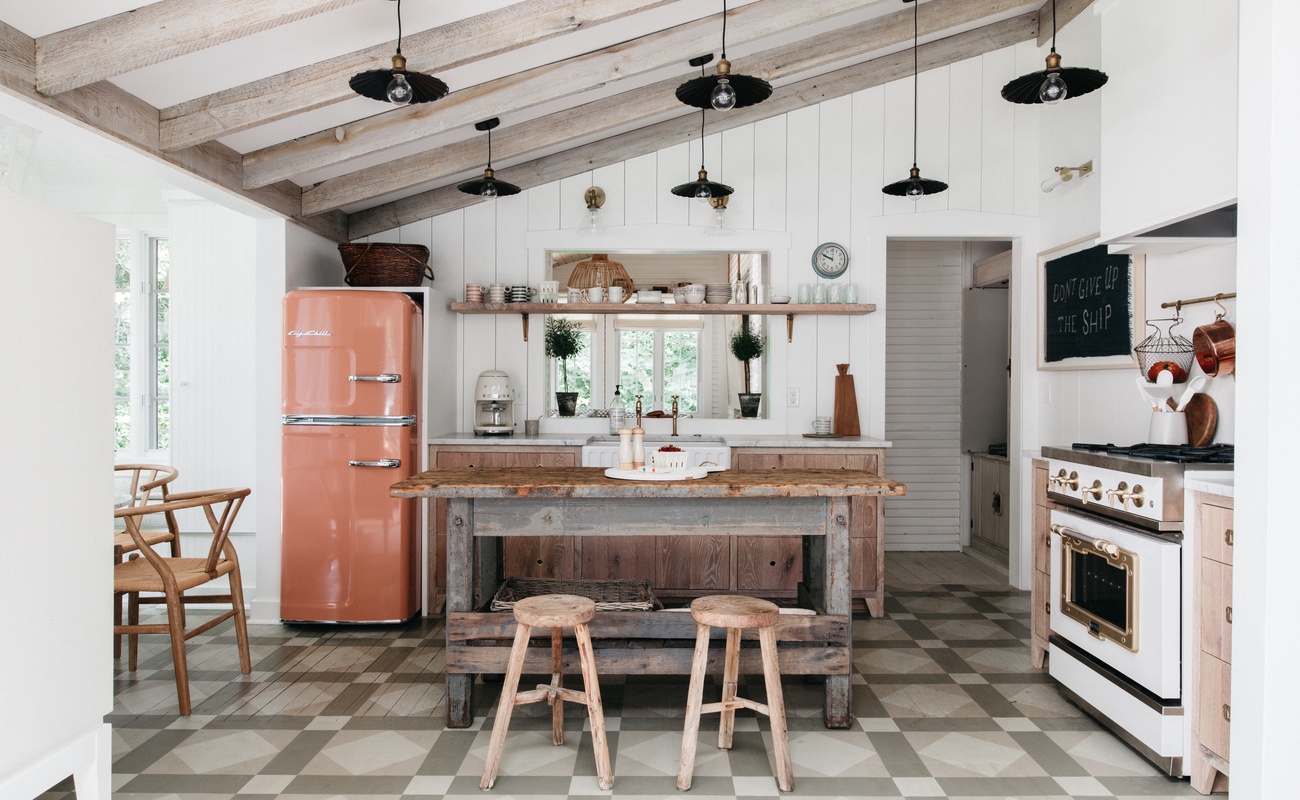 The well-equipped kitchen includes a center prep island with bar stools for entertaining,