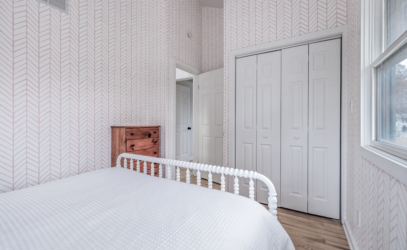 This ambient-chic bedroom with playful wallpaper and sunshine pouring in is the perfect retreat after a day of adventure or chill.