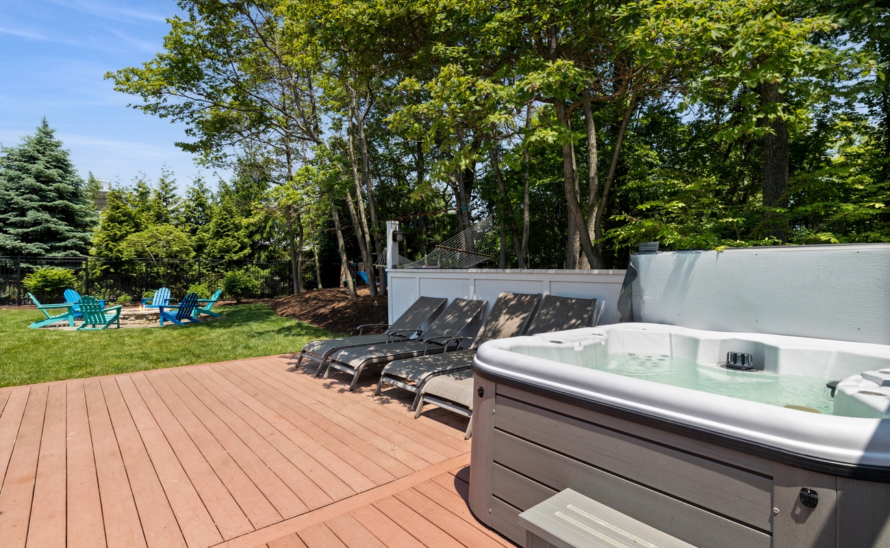 Surrounded by lush greenery, the hot tub offers a peaceful spot to relax and unwind.