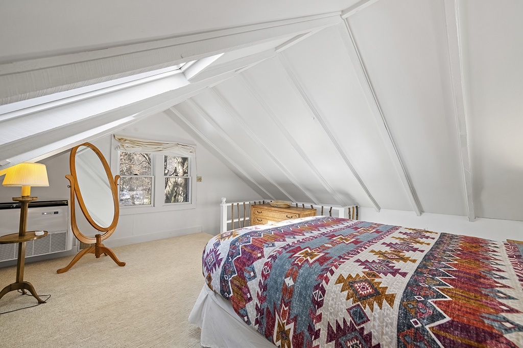 The Cottage loft invites slow mornings beneath soft light and rustic beams.