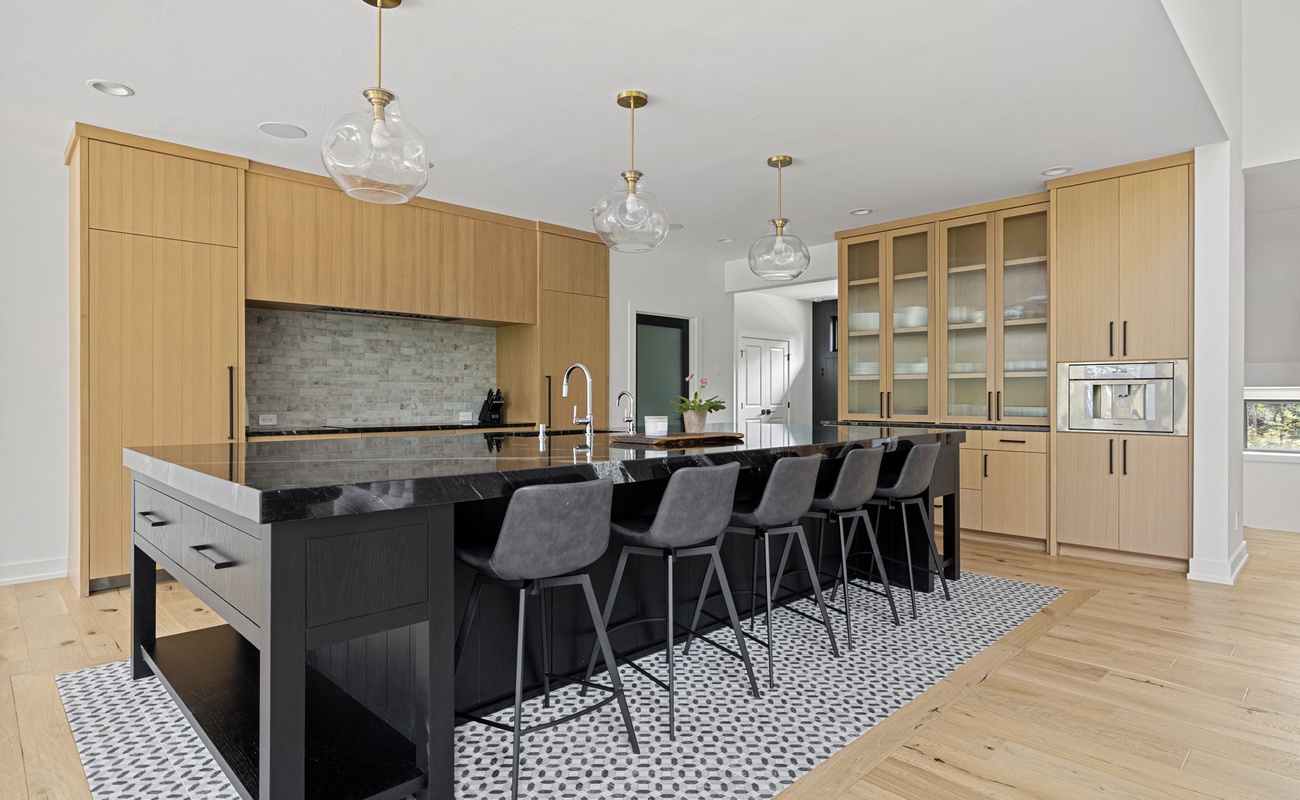 Cooking up some magic in this sleek kitchen with a black island and wooden cabinets!