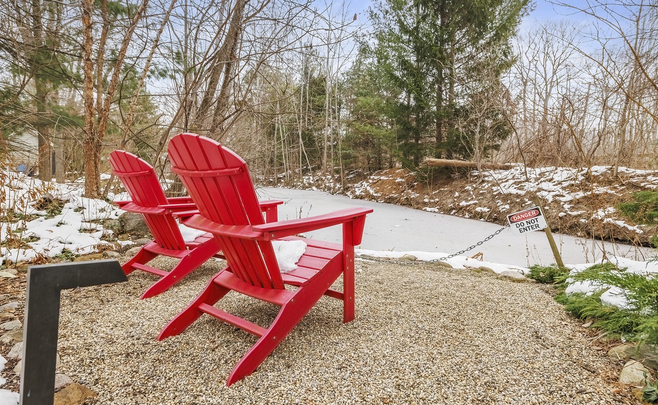 Bright red chairs for quiet moments in Star Cottage’s wooded yard.