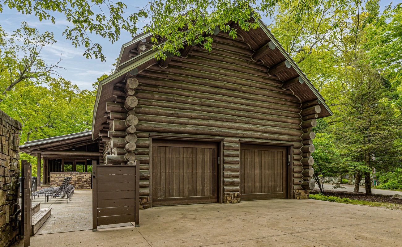 This stunning log home features two spacious garages and a welcoming driveway.