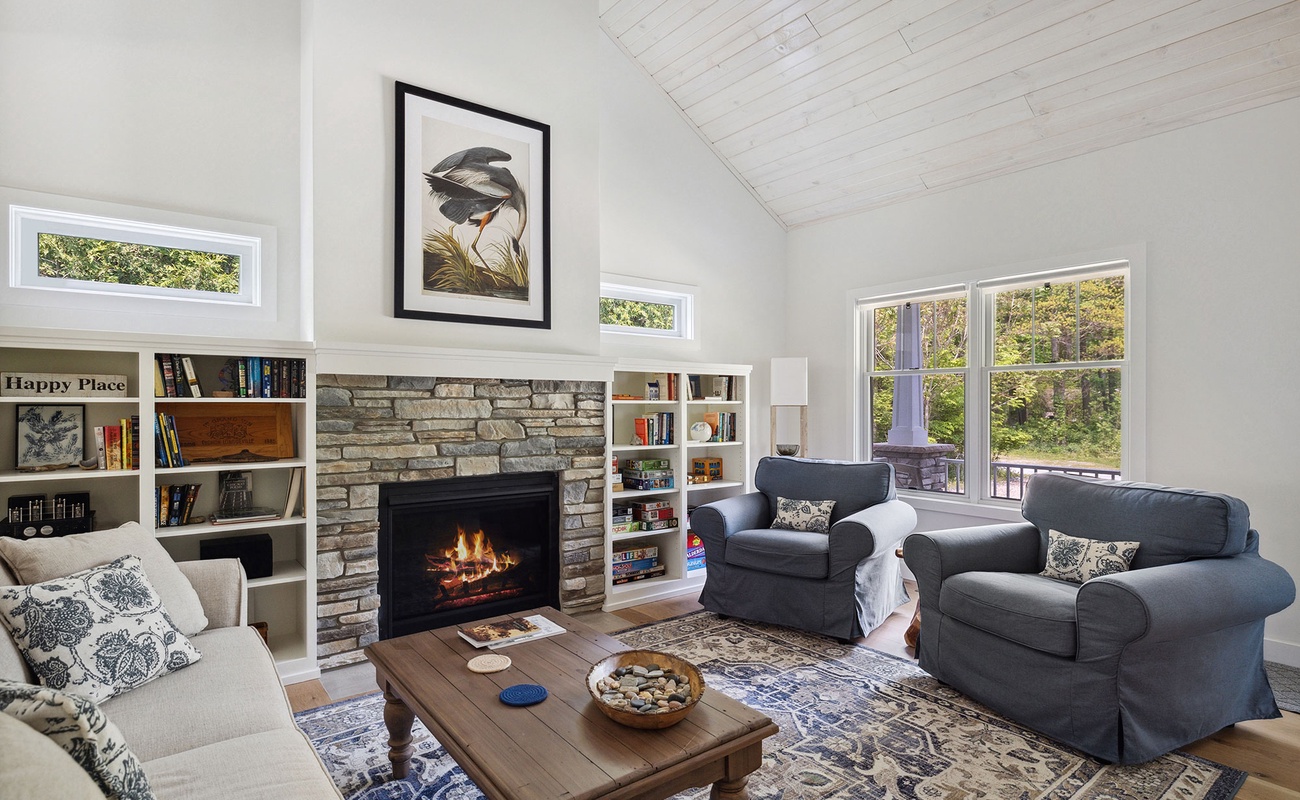 Lounge in the cozy living area with stone-trimmed fireplace in chillier weather.