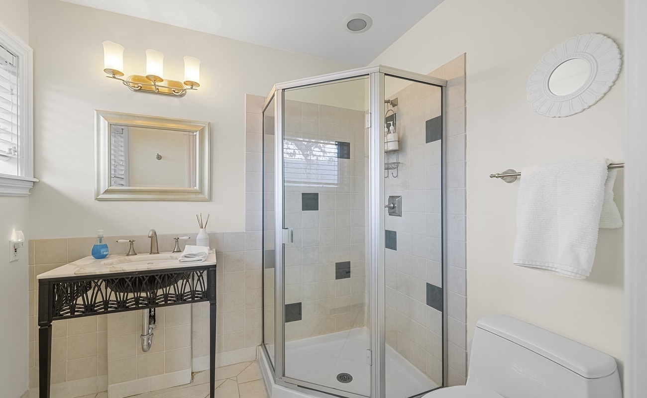 Spacious bathroom with walk-in shower, elegant fixtures, and natural light.