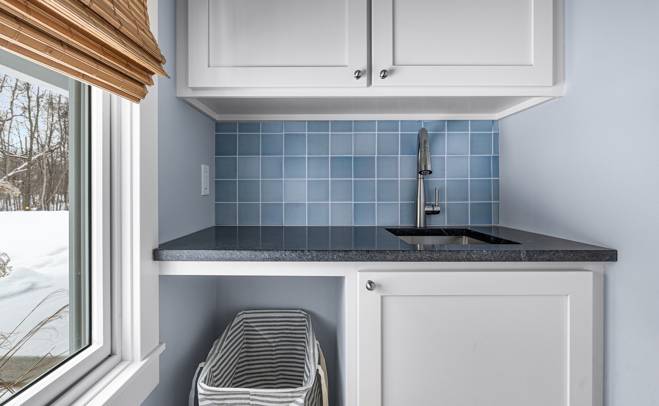 Charming and functional! A stylish laundry sink with a fresh coastal vibe.