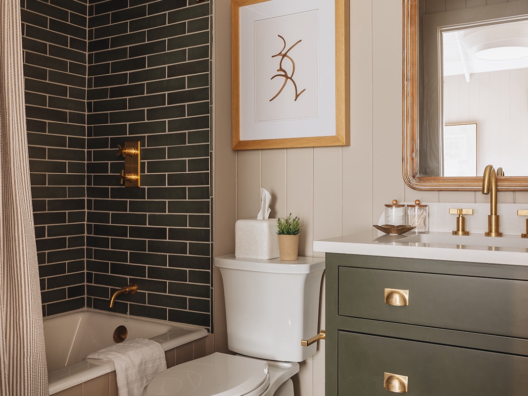 This bathroom has a chic vanity sink and a soaking tub with a Rain Shower head.