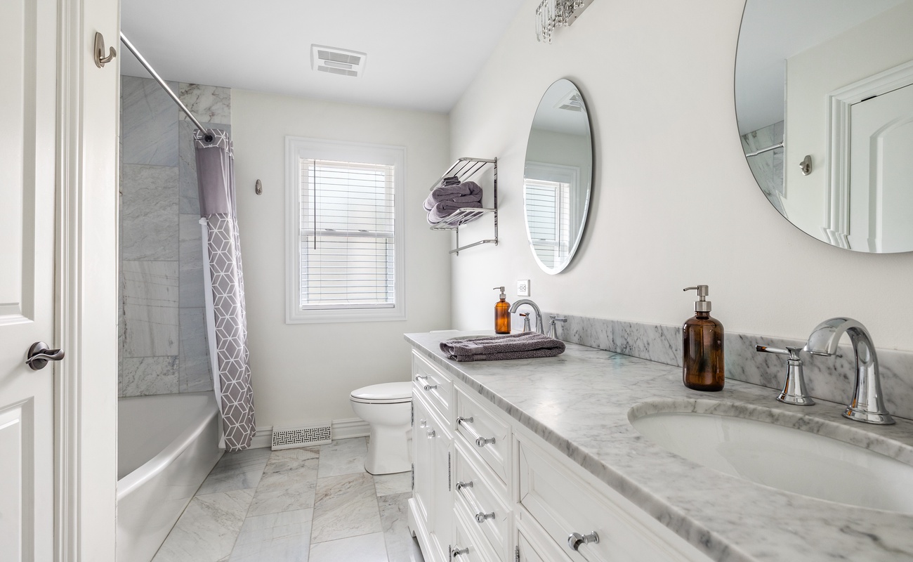 Modern bath with marble, double sinks, tub, and luxe essentials included.
