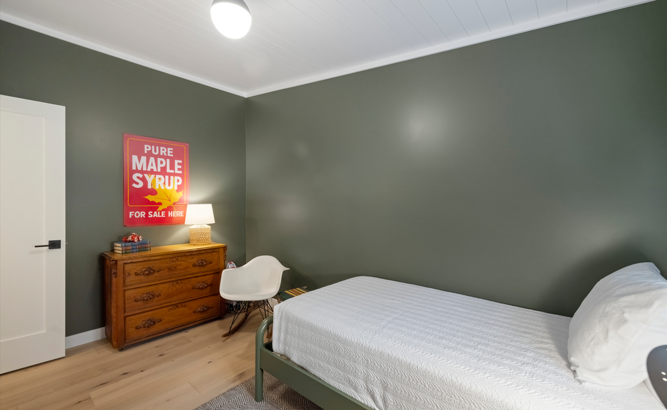 A warm single room with vintage charm and woodland tones.